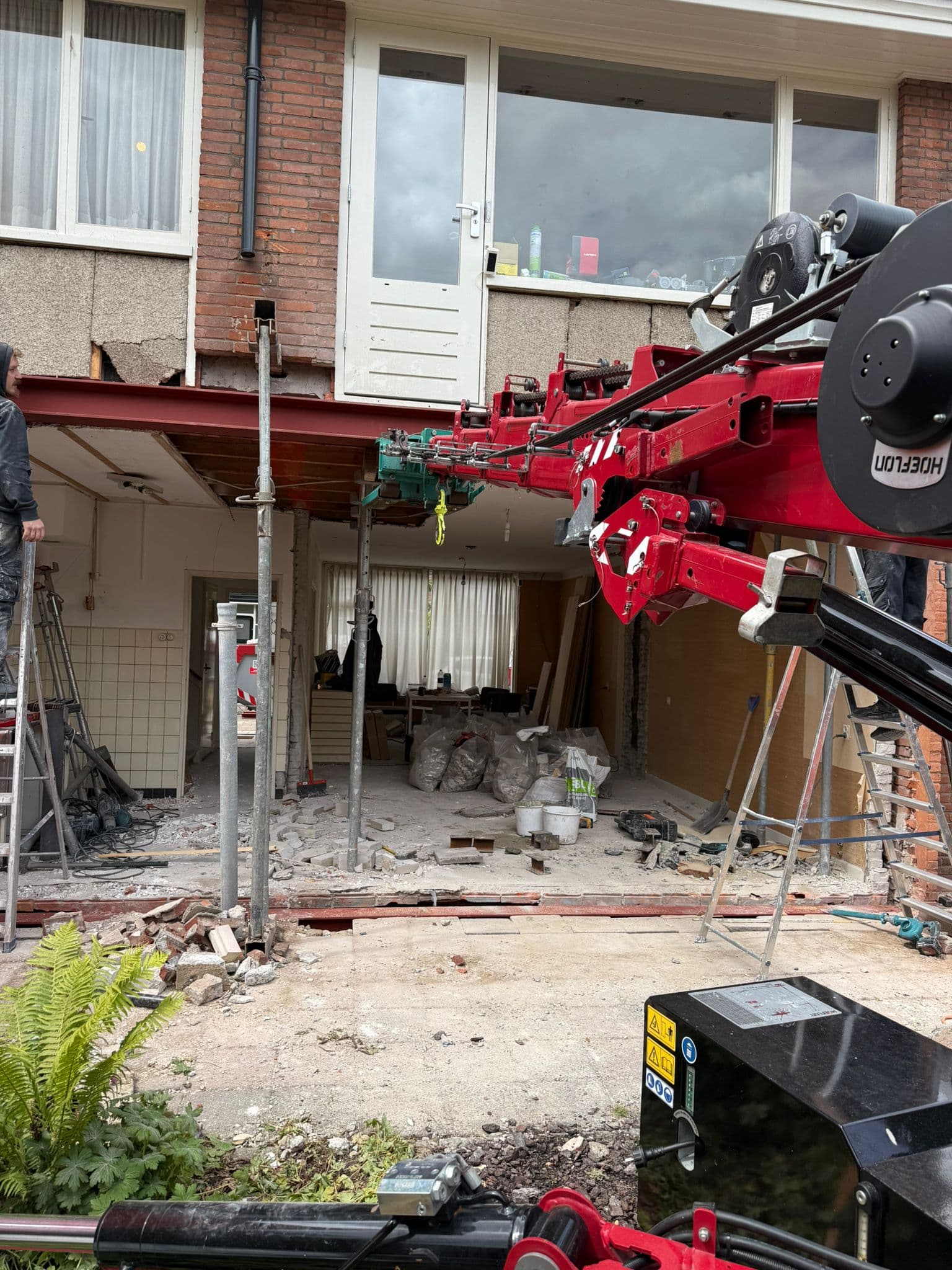 Minikraan plaatst stalen H-balk bij woningrenovatie