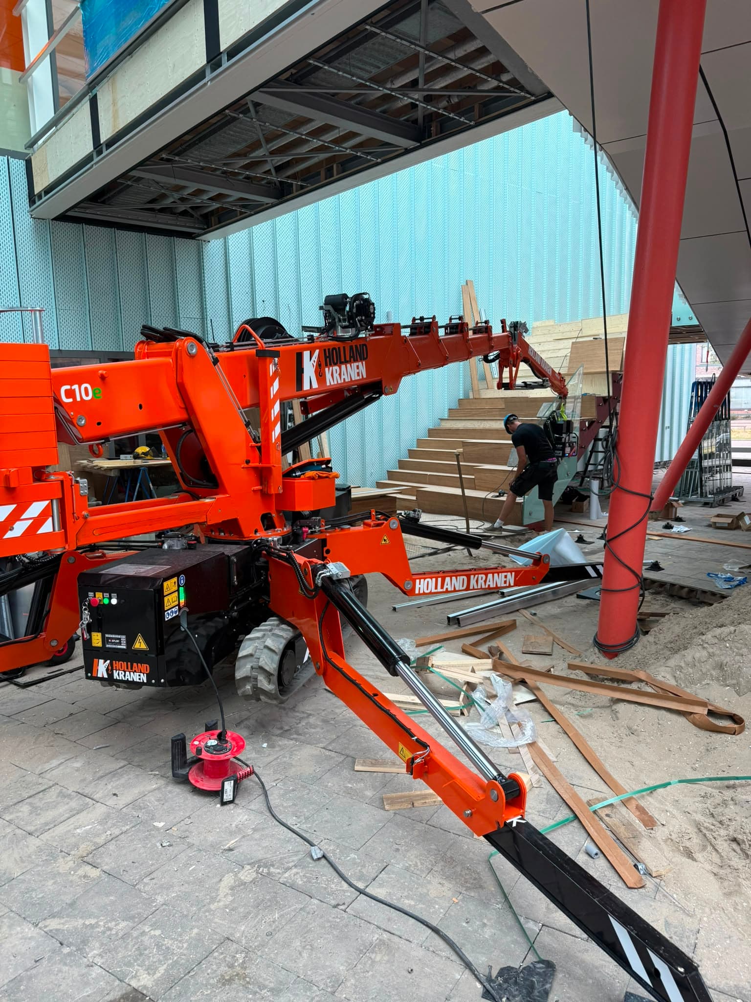 Hoeflon C10e tijdens inpandig hijswerk in een gebouw in aanbouw