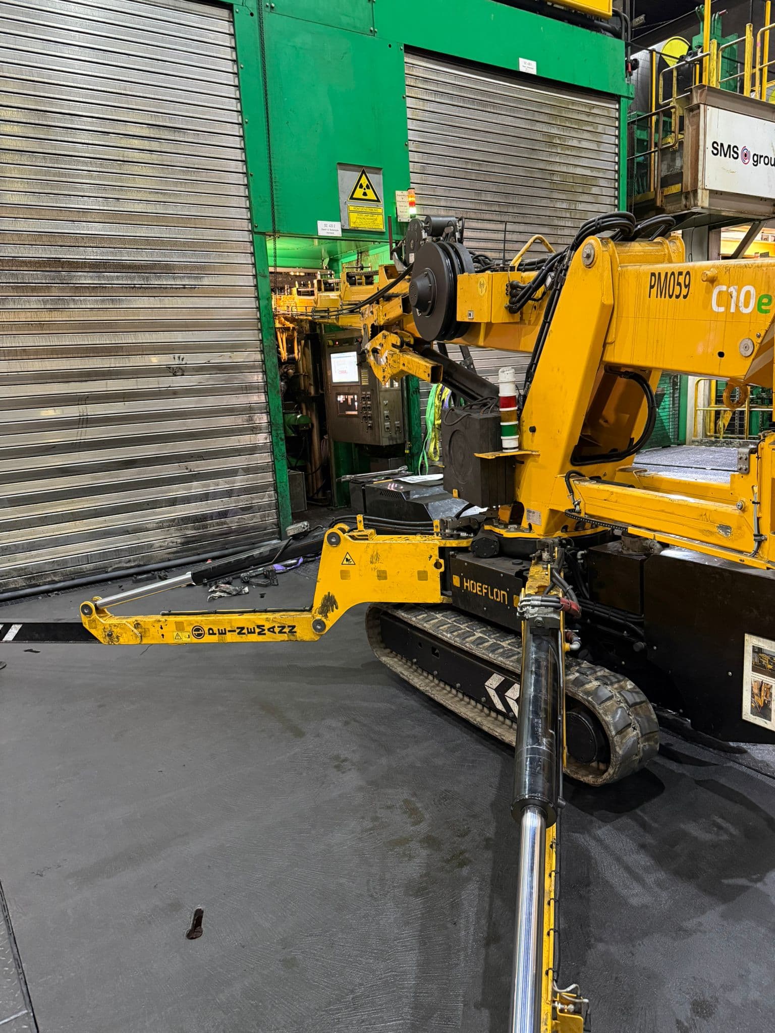 Hoeflon C10e hijst inpandig door een deuropening in een fabriekshal
