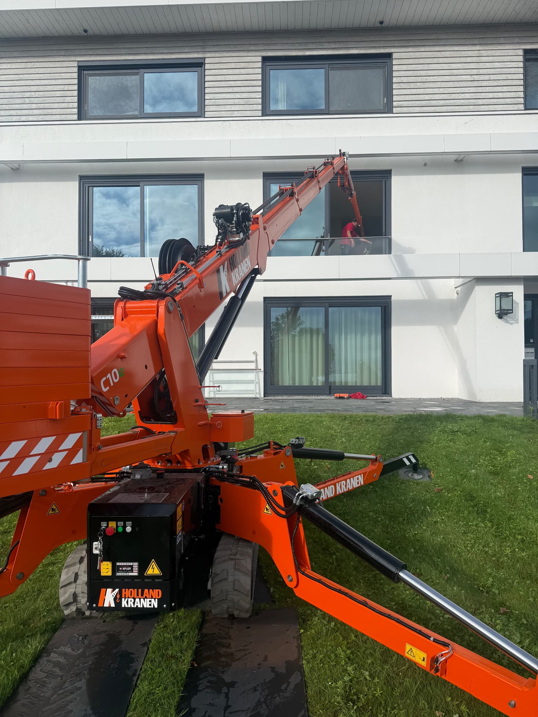 Hoeflon C10 op rijplaten en stempelplaten in de tuin, met de giek omhoog naar het appartement