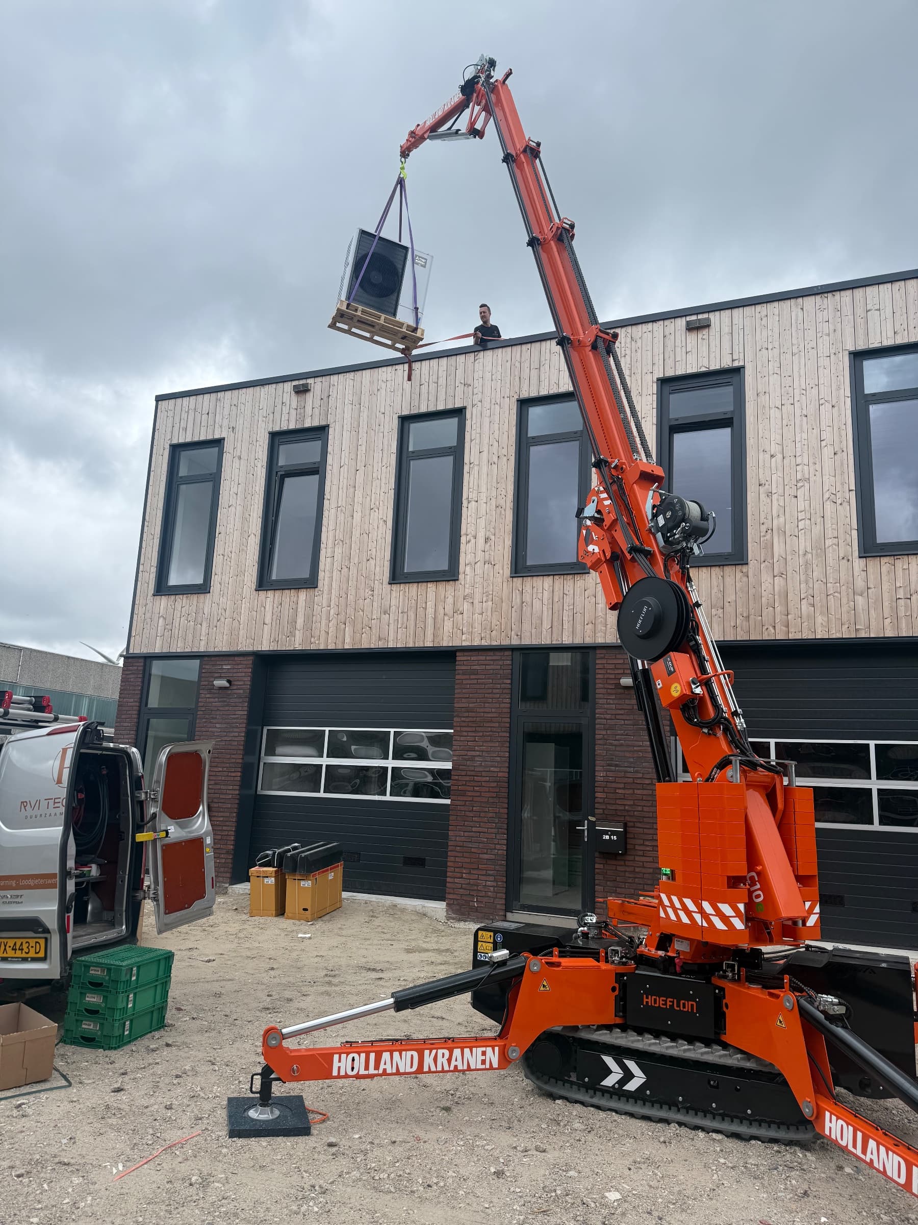 Warmtepomp op een pallet gaat met de Hoeflon C10 naar het platte dak van een bedrijfspand